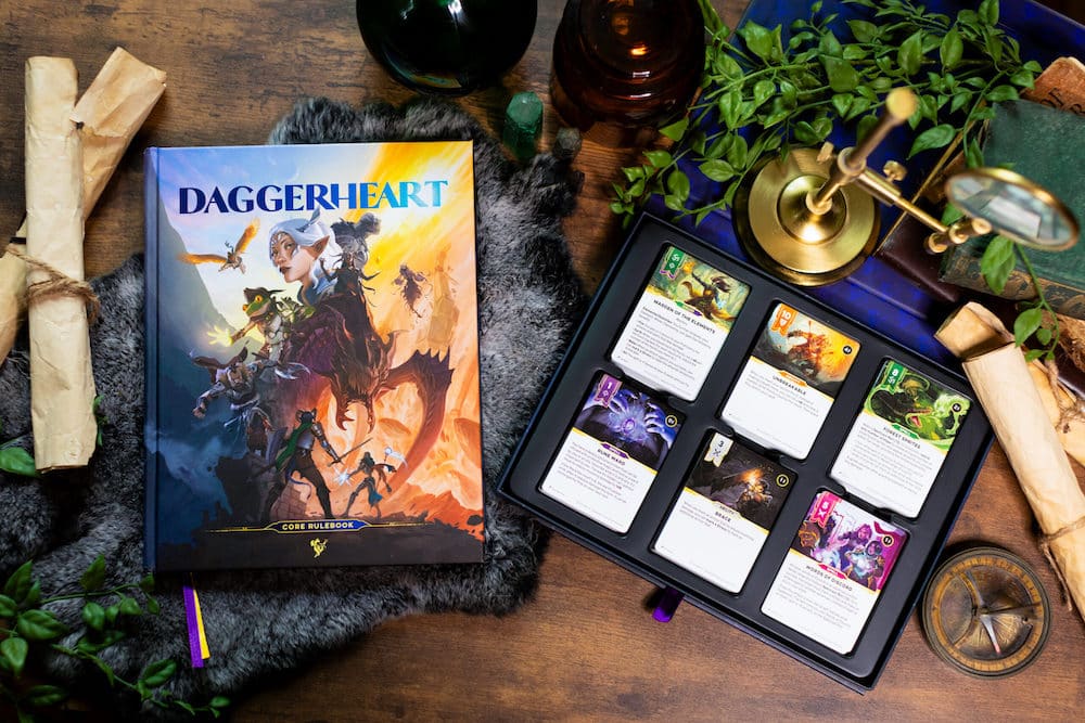 Le Core Set de Daggerheart : le livre de r&egrave;gles Core Rulebook et son coffret de cartes de personnages, photographi&eacute;s sur une table en bois